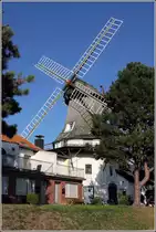 Wittmund. Etwas versteckt hinter B�umen und anderen Geb�uden steht diese Windm�hle im Stadtteil Carolinensiel. Sie wurde 1742 als Galerieholl�nder auf dem Deich errichtet. Heute enth�lt sie Ferienwohnungen. 18.09.2018