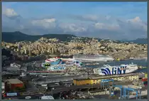 Der 76 m hohe Leuchtturm von Genua gew�hrt einen eindrucksvollen Blick �ber die Hafenanlagen und die Stadt. Genua ist ein bedeutender Anlaufpunkt f�r Kreuzfahrtschiffe. Gleichzeitig starten hier auch F�hren nach Korsika und Sardinien. Im Hintergrund ist das Stadtzentrum von Genua zu sehen, etwa in Bildmitte befindet sich der <a href= http://www.bahnbilder.de/bild/italien~e-loks~e402b/1112329/der-bahnhof-genova-piazza-principe-liegt.html >Bahnhof Genova Piazza Principe</a>. Rechts liegt der alte Hafen Porto Antico. (Genua, 22.09.2018)