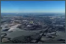 Blick auf Stendal von Westen: Die Wohnbl�cke des ab 1971 entstandenen Neubaugebietes Stadtsee dominieren das Stadtbild nahe dem gleichnamigen See. Rechts des Sees liegt der Bahnhof Stendal, von dem aus sich im Vordergrund die Strecken nach Wittenberge (links in gro�en Bogen die Stadt umrundend), Uelzen und Wolfsburg (Mitte) ausf�deln. Im Hintergrund dampfen die Anlagen des Zellstoffwerks Arneburg. (18.01.2019)