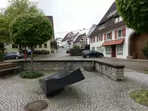 Bittelbronn, Brunnen am Kirchplatz, dahinter Geb�ude in der Dettinger Stra�e (10.05.2018)