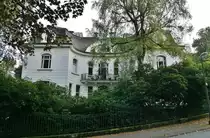 Diese Villa ist in der Goebenstra�e im Briller-Viertel von Wuppertal zu finden.
Das gr��te zusammenh�ngende Villen-Viertel Deutschlands, das Briller-Viertel in Wuppertal, lockt mit fast 300 dieser Prachtexemplare, auf die H�henz�ge nah der Innenstadt und der kleinen aber feinen  Altstadt , dem Luisenviertel, das sich mit den umliegenden, riesigen Best�nden an Gr�nderzeit- und Jugendstilbauten z.B. auf dem �lberg, immer mehr zum Kreuzberg NRW's und dem kreativen Kietz schlechthin entwickelt. Eine der dortigen Villen, ist die als  Galerie Parnass  in der Kunstwelt legend�re und ber�hmte Villa Jaehrling, in der, wie es die FAZ beschrieb, 1963 eine der Schl�sselausstellungen des 20 Jahrhunderts mit Joseph Beuys, Bazon Brock, Charlotte Moorman, Nam June Paik, Eckart Rahn, Tomas Schmit und Wolf Vostell stattfand. Das Happening war der Kristallisations-Punkt der Fluxus-Bewegung in Deutschland. Ferner wohnten unter anderem die Dichterin Else-Lasker-Sch�ler, Bayer und IG-Farben-Chef Carl Duisberg und Johannes Rau im Briller-Viertel. 03.10.2011