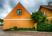 Typisch gelben H�user am Kallhoi in Kupferm�hle (Gemeinde Harrislee). Die Siedlung liegt an der direkt an der deutsch-d�nischen Grenze. Der Name des Ortes entstand aus dem Hammerwerk, das der d�nische K�nig Christian IV. im 17. Jahrhundert an der Krusau anlegen lie� und dessen M�hlrad durch das Wasser der Au getrieben wurde. Wie der Ortsname aussagt, wurde im Werk Kupfer verarbeitet.
Aufnahme: 1. Juni 2019.