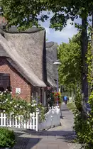 Reetdachh�user und Fu�weg der Hauptstra�e in Alkersum auf F�hr. Aufnahme: 3. Juli 2019.