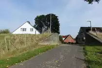 Blick in den Ort Hetlingen in der Haseldorfer Marsch am 15.10.2019: Durchfahrt am alten Winterdeich, hier wurden bis zur Fertigstellung des Landesschutzdeiches (Bauzeit 1945-1978) Bretter in die links und rechts in den Beton eingebrachten Schienen gesteckt, um den Deich zu schlie�en /