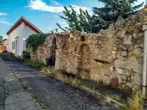 Historischer Steinzaun mit eingebautem Rastbank. Ausser der Innenstadt findet man im Stadteil Tettye noch ziemlich viel Altbau. Foto: 07.2020, Ungarn, P�cs, Kisboldogasszony utca.