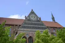 Nikolaikirche in der Hansestadt Wismar - Giebeldreieck des S�dquerhauses mit Ma�werkrosette und Galerien von Relieffiguren aus Terrakotta. Aufnahme: 18. Juni 2022.