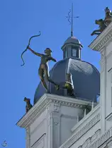 Ein kunstvoll gestaltetes Figurenensemble auf dem Dach eines von 1925 bis 1927 gebauten Geb�udes, in dem sich heute das Hyatt Centric Hotel befindet. (Madrid, November 2022)