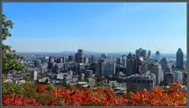 Vom Mont Royal hat man einen guten �berblick �ber die Downtown von Montreal. Im Vordergrund sind mehrere Geb�ude der McGill-Universit�t zu sehen, dahinter die Hochh�user im Stadtzentrum. Architektonisch sticht vor allem der Atrium Le 1000 am rechten Bildrand hervor. Im Hintergrund ist der Sankt-Lorenz-Strom erkennbar. (Montreal, 11.10.2022)