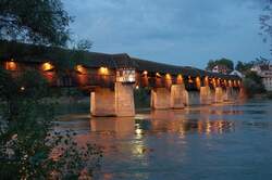 Holzbr�cke - Die Lichter der 400 Jahre alten Br�cke, nach Pl�nen des bekannten Br�ckenbaumeisters Blasius Baldischwiler, spiegeln sich im ruhigen Wasser des Rheins.